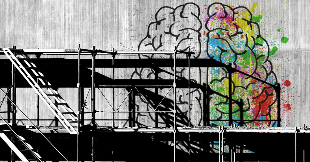 Image of a brain on a concrete wall with scaffolding in front of it.