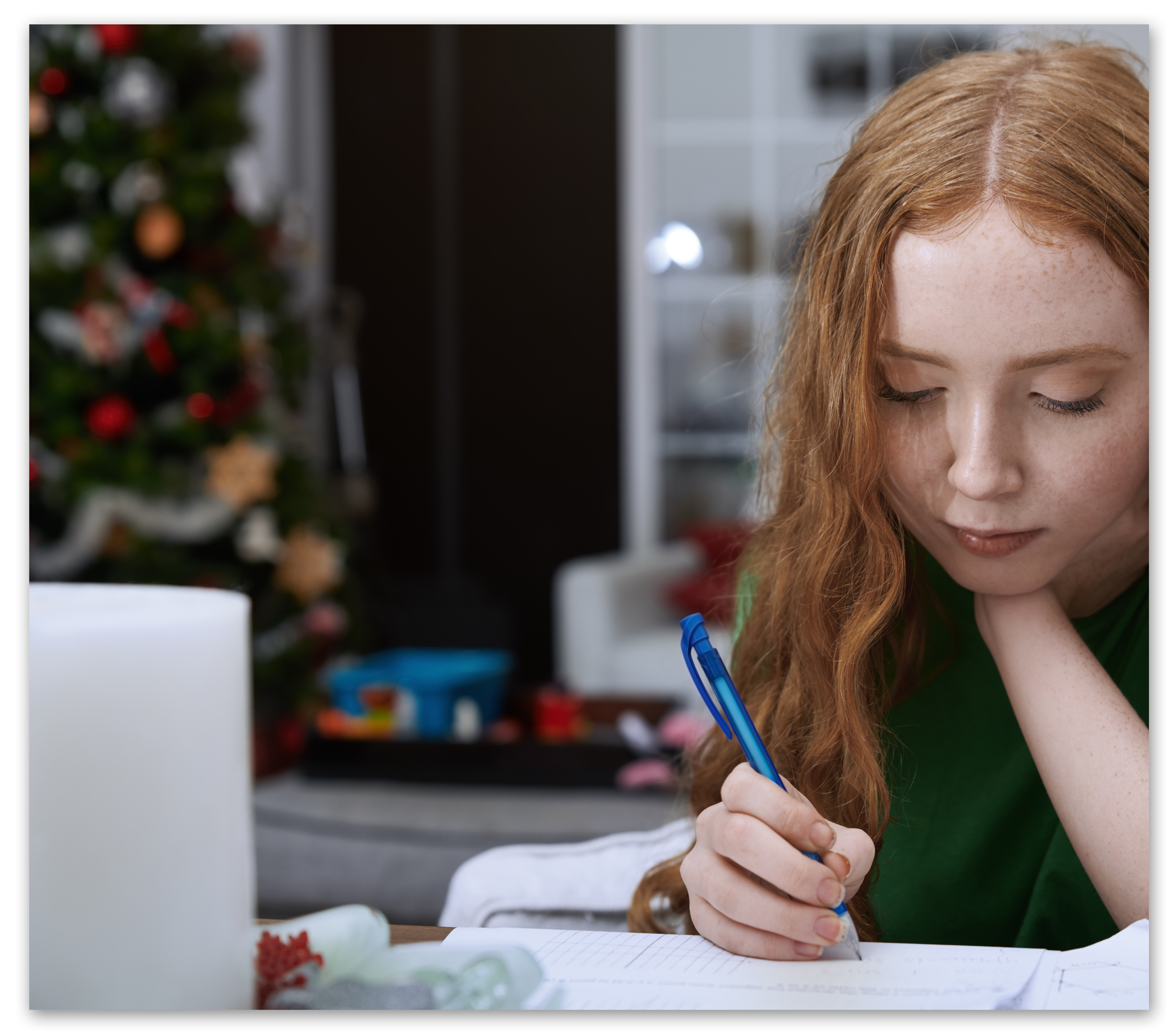 Red-headed girl doing homework on laptop in her home