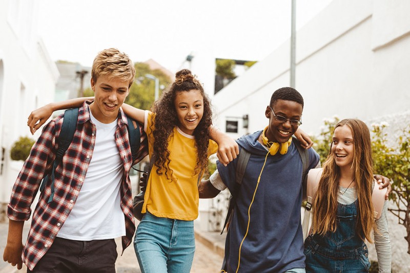 Students walking down a street together, laughing