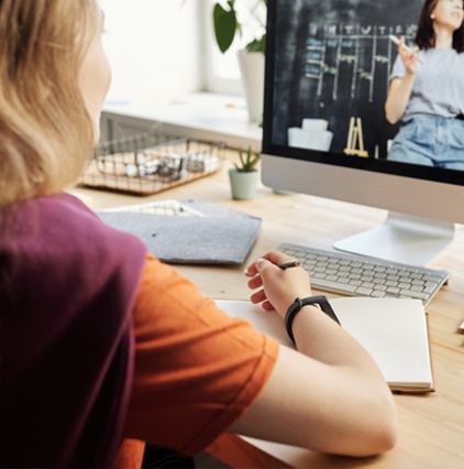 Young blonde girl taking notes during a virtual synchronous class